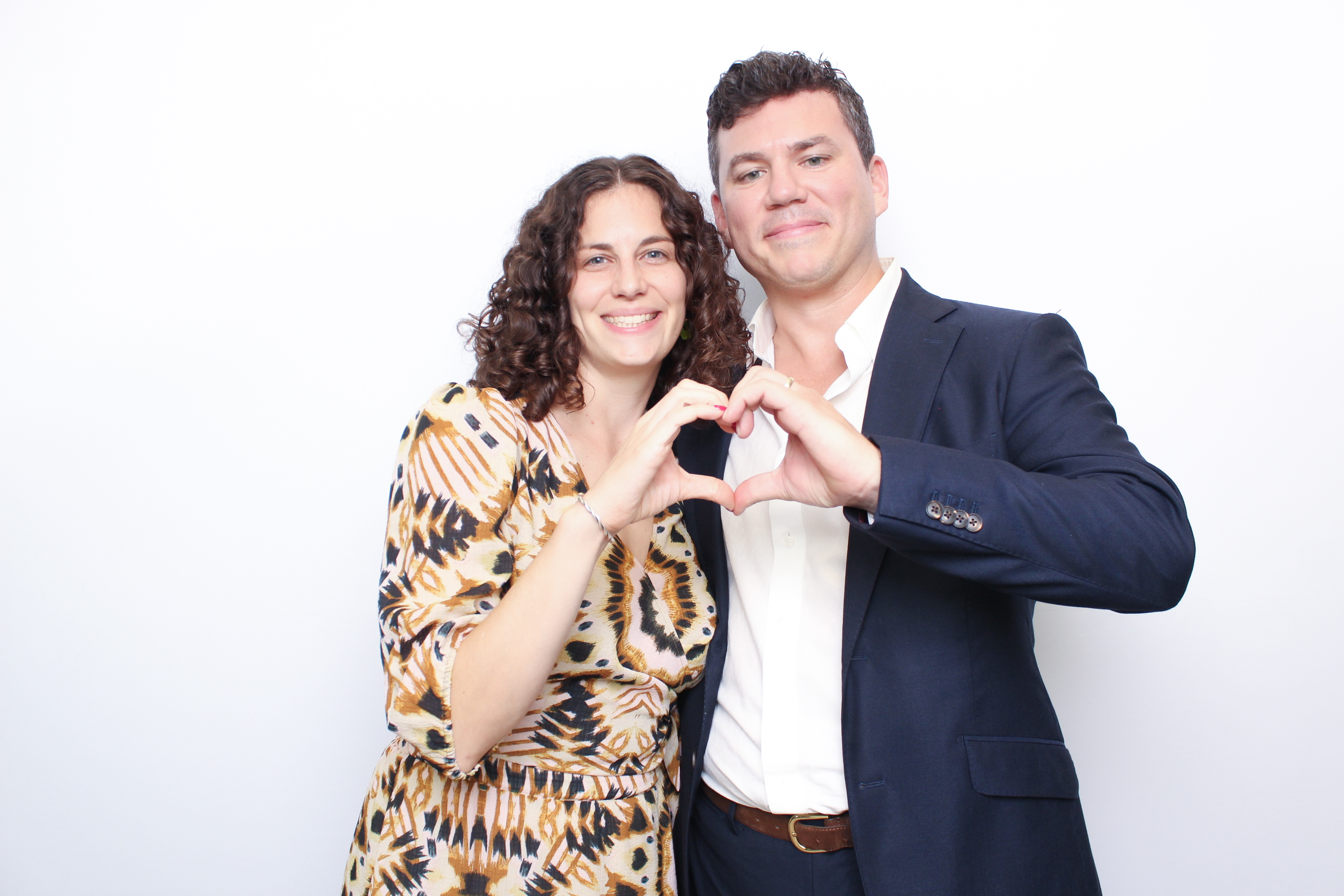 Couple making heart hands at photo booth